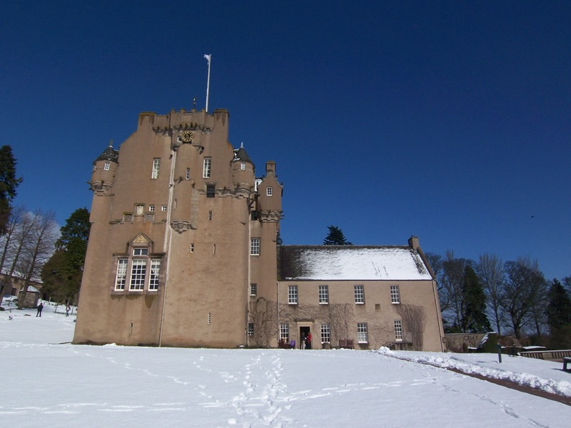 Crathes Castle with snow and blue skies