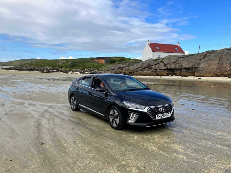 Kid having fun driving a car on Traigh Mhor beach on Barra