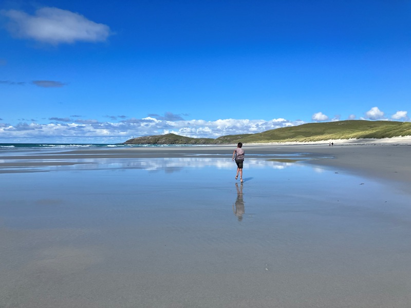 Traigh Eais beach on Barra with happy child running on the sand