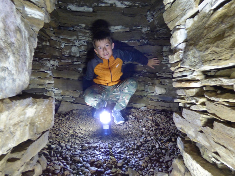 Exploring inside the tight spaces of Wideford Hill Burial Cairn with a torch